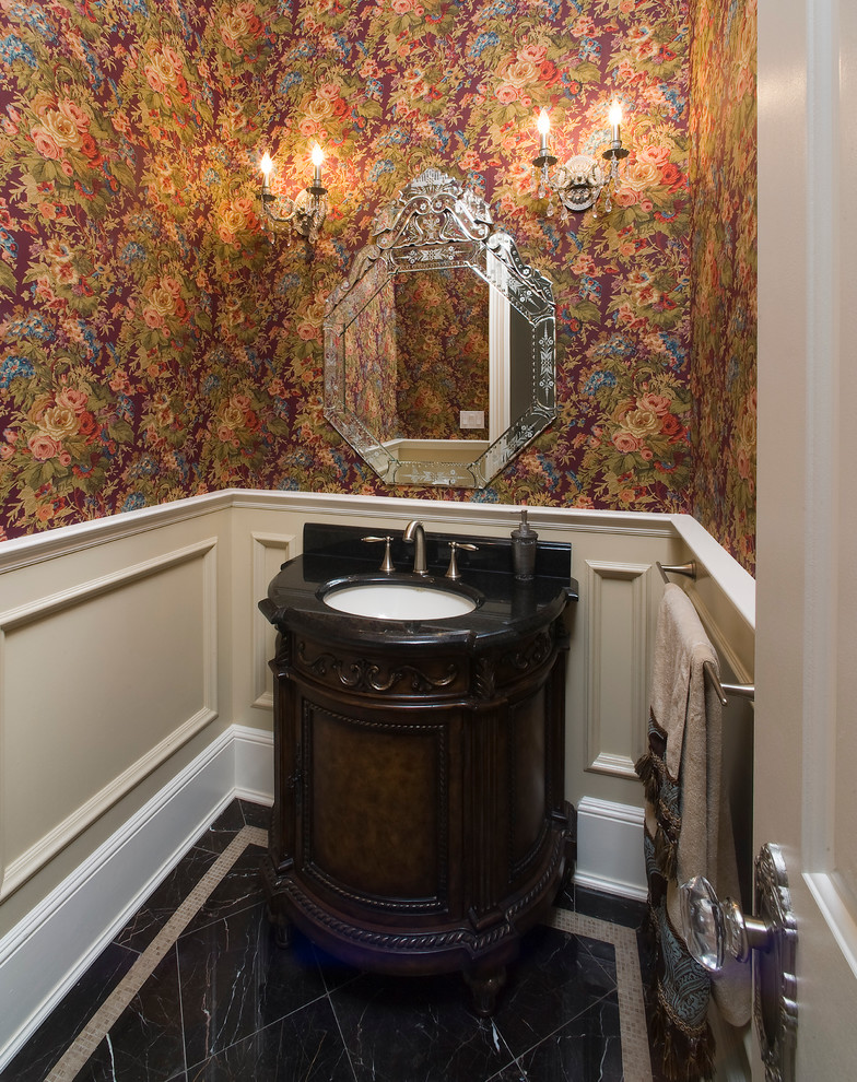Inspiration for a mid-sized traditional powder room in New York with an undermount sink, furniture-like cabinets, dark wood cabinets, quartzite benchtops, a two-piece toilet, multi-coloured walls and black benchtops.