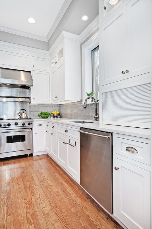 Kitchen - mid-sized transitional l-shaped light wood floor and beige floor kitchen idea in Chicago with an undermount sink, shaker cabinets, white cabinets, quartzite countertops, gray backsplash, subway tile backsplash, stainless steel appliances and an island