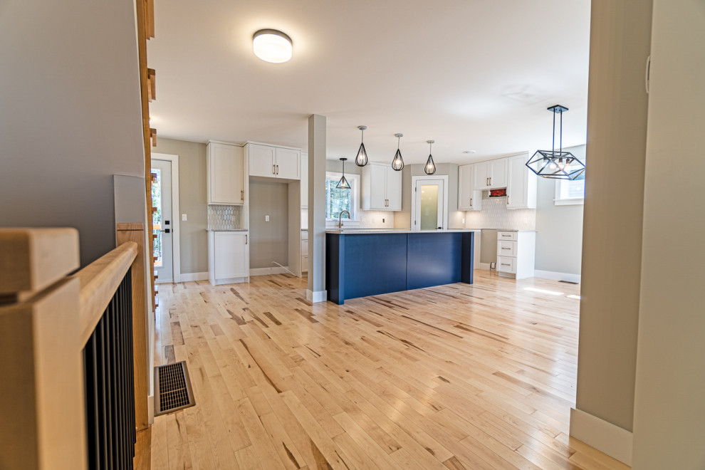 Eat-in kitchen - mid-sized transitional light wood floor and beige floor eat-in kitchen idea with shaker cabinets, white cabinets, granite countertops, an island and gray countertops