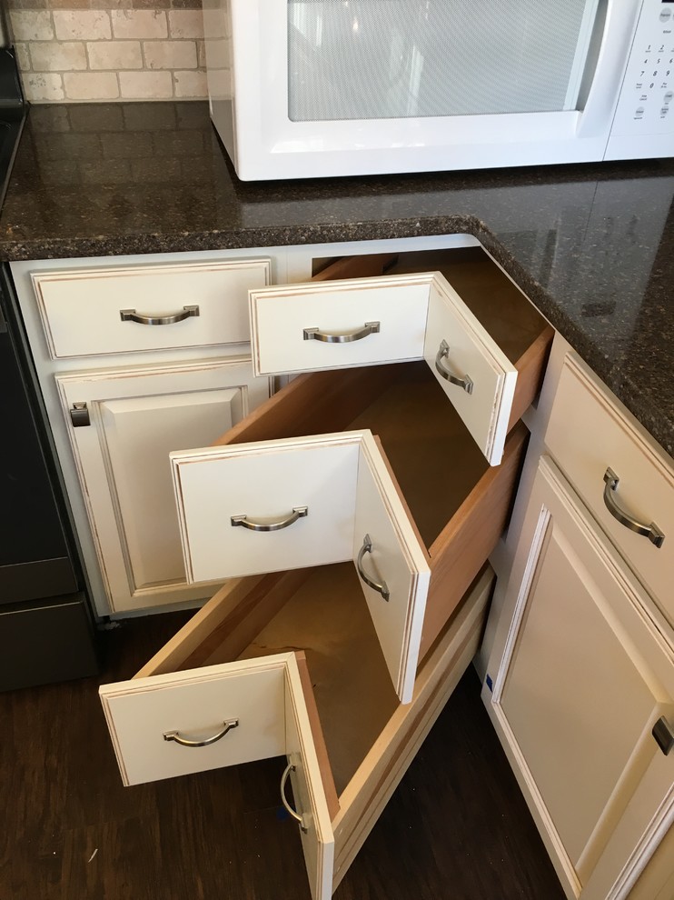 Inspiration for a mid-sized traditional l-shaped kitchen pantry in Other with a farmhouse sink, raised-panel cabinets, beige cabinets, quartzite benchtops, beige splashback, travertine splashback, stainless steel appliances, vinyl floors, with island and brown floor.