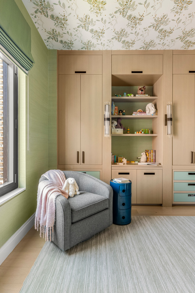 Design ideas for a mid-sized transitional nursery in New York with green walls, light hardwood floors, beige floor, wallpaper and wallpaper.