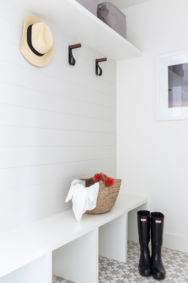 Photo of a country mudroom in San Francisco with white walls and grey floor.