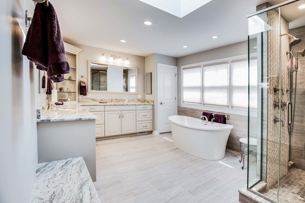 Freestanding bathtub - large transitional master brown tile, beige tile and porcelain tile porcelain tile and beige floor freestanding bathtub idea in Chicago with raised-panel cabinets, white cabinets, beige walls, an undermount sink, granite countertops, a hinged shower door and beige countertops