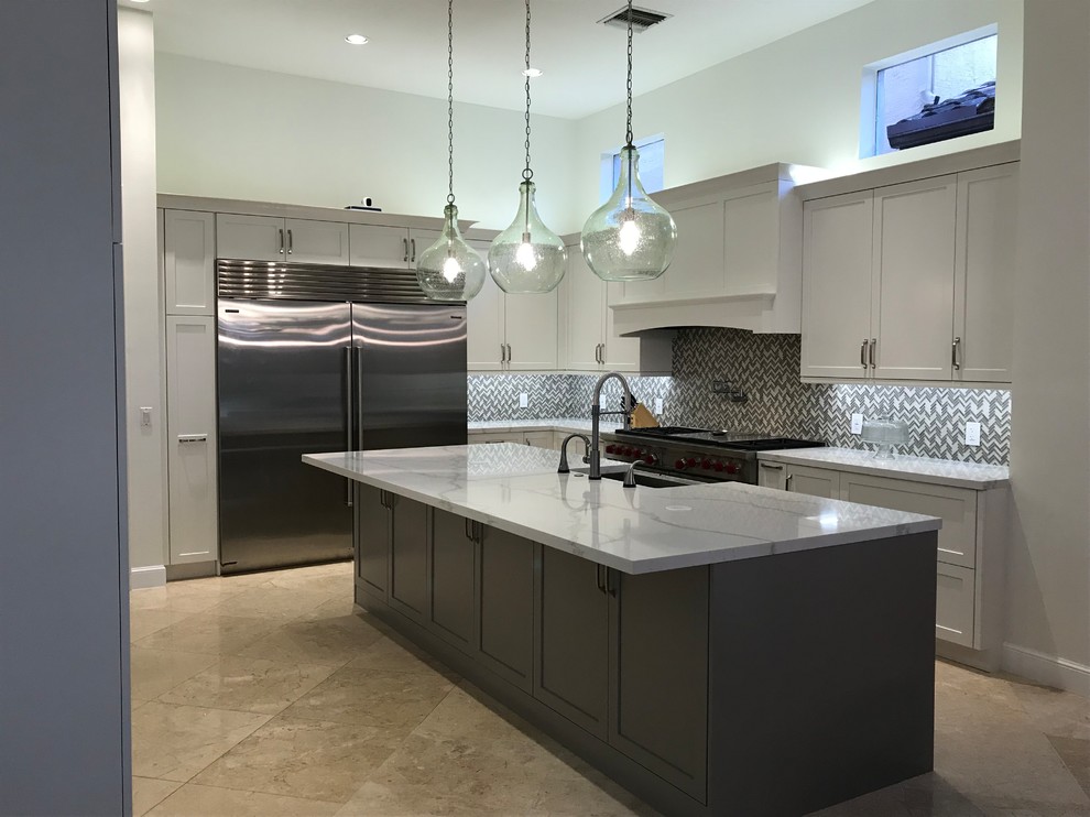 Inspiration for a large transitional kitchen remodel in Miami with a farmhouse sink, shaker cabinets, white cabinets, quartz countertops, gray backsplash, glass tile backsplash, stainless steel appliances, an island and multicolored countertops