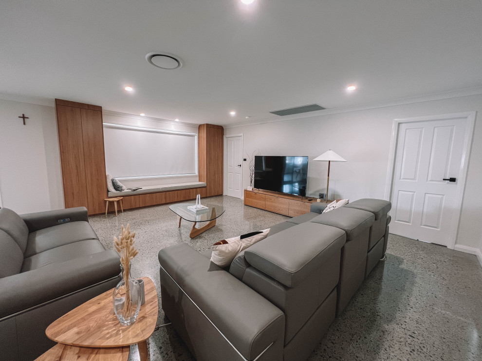 シドニーにある高級な中くらいな北欧スタイルのおしゃれなLDK (白い壁、コンクリートの床、据え置き型テレビ、グレーの床、板張り天井、板張り壁) の写真