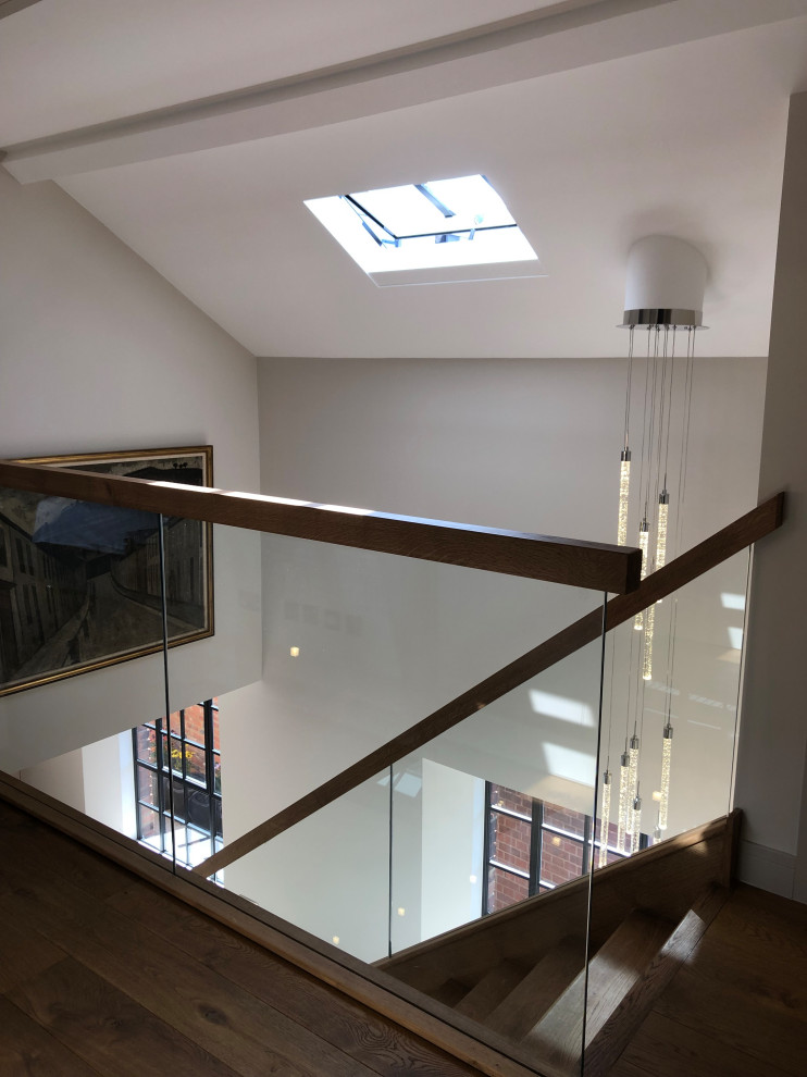 Contemporary wood straight staircase in Surrey with wood risers and metal railing.