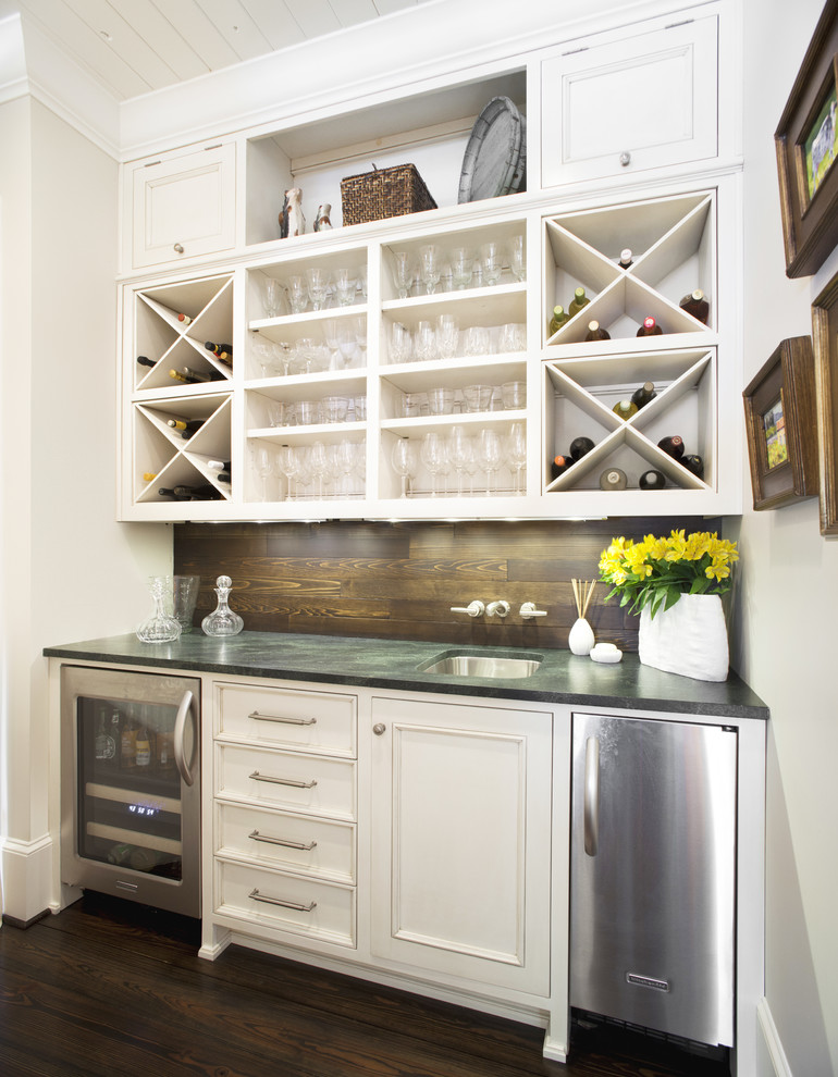 Photo of a traditional single-wall wet bar in Jacksonville with dark hardwood floors, an undermount sink, white cabinets, recessed-panel cabinets and soapstone benchtops.