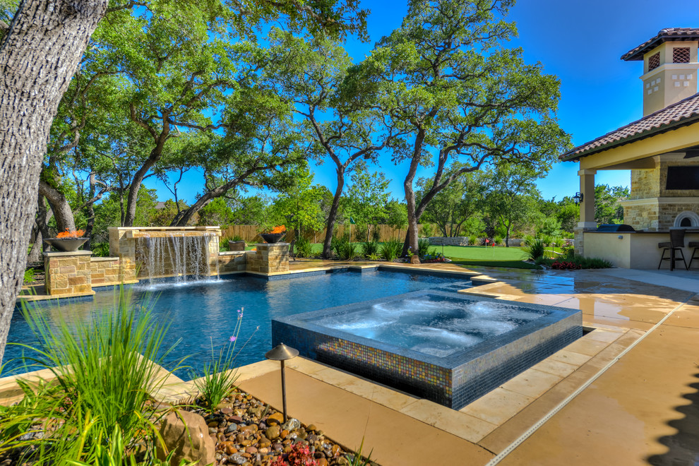 Design ideas for a large mediterranean backyard custom-shaped pool in Austin with a hot tub and concrete pavers.