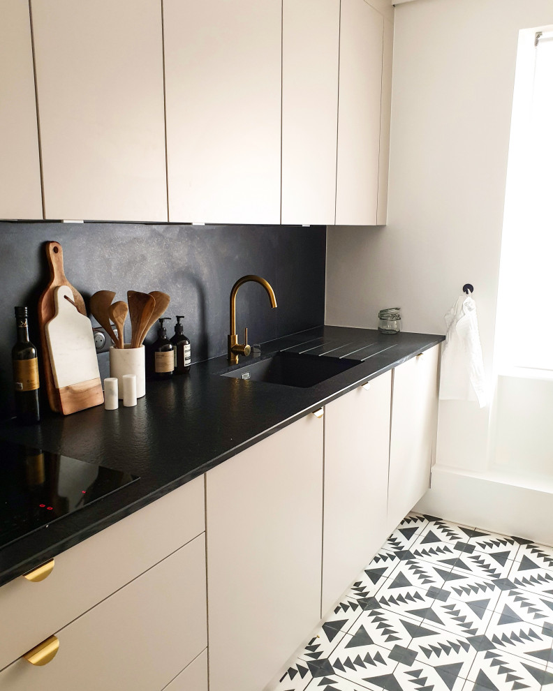 Inspiration for a mid-sized transitional single-wall separate kitchen in Strasbourg with an undermount sink, beaded inset cabinets, beige cabinets, granite benchtops, black splashback, panelled appliances, cement tiles, no island, black benchtop and coffered.