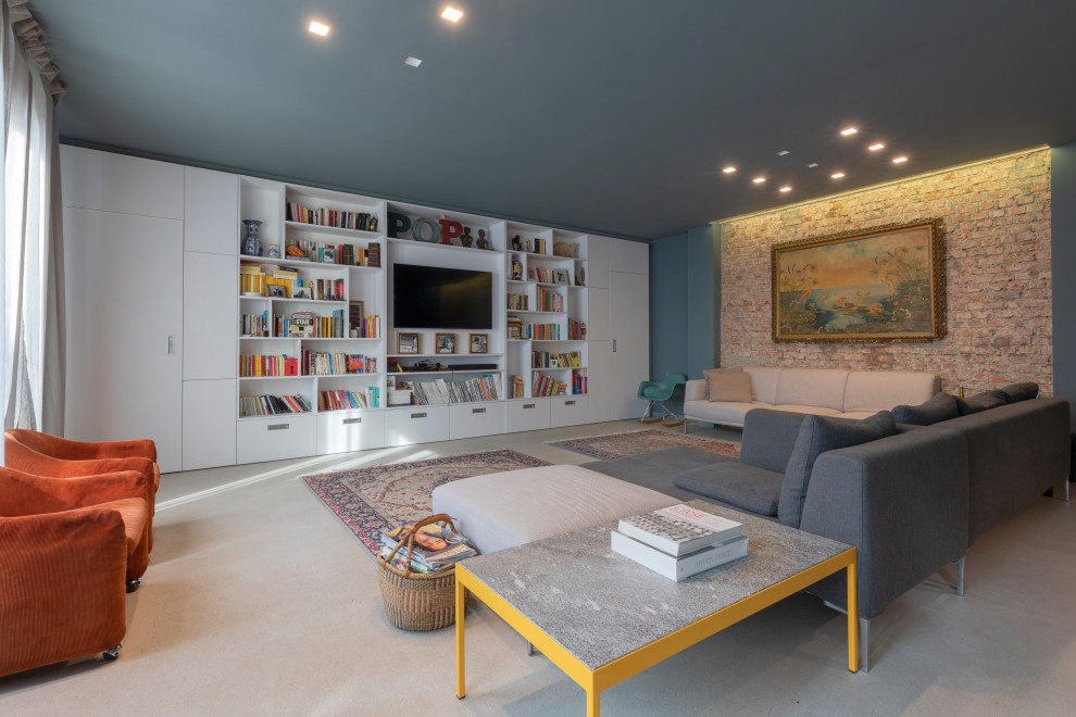 На фото: большая двухуровневая гостиная комната в современном стиле с синими стенами, бетонным полом, телевизором на стене и серым полом