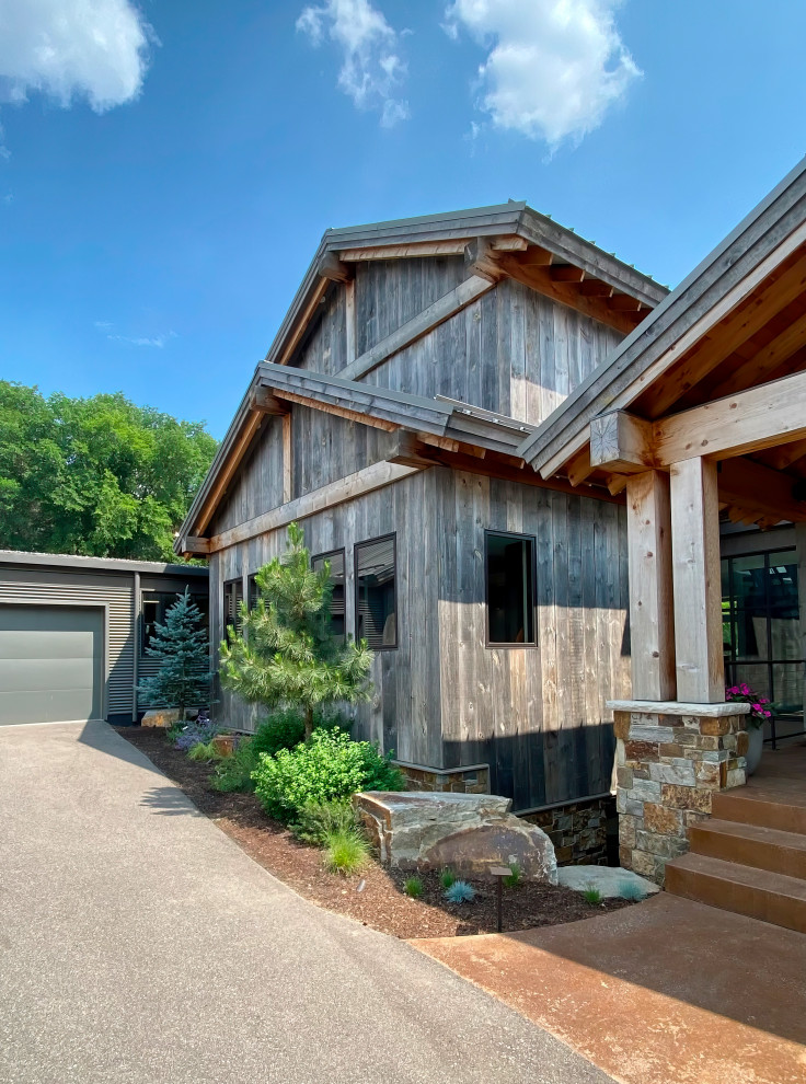 Example of a mountain style wood house exterior design in Minneapolis with a metal roof and a gray roof
