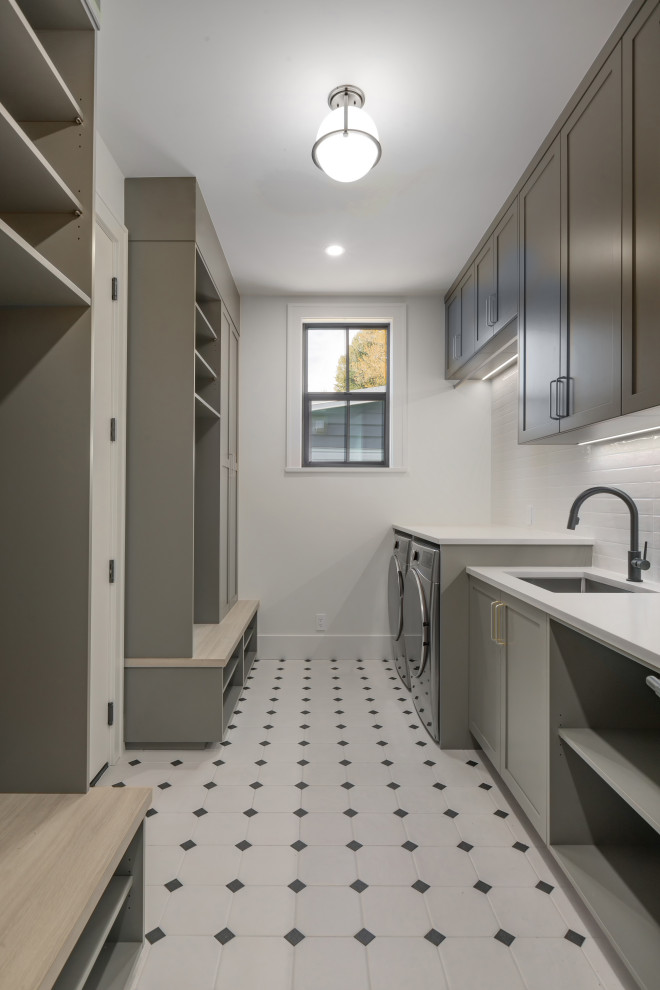 Large contemporary galley dedicated laundry room in Vancouver with an undermount sink, shaker cabinets, grey cabinets, quartz benchtops, white splashback, porcelain splashback, white walls, porcelain floors, a side-by-side washer and dryer, white floor and white benchtop.