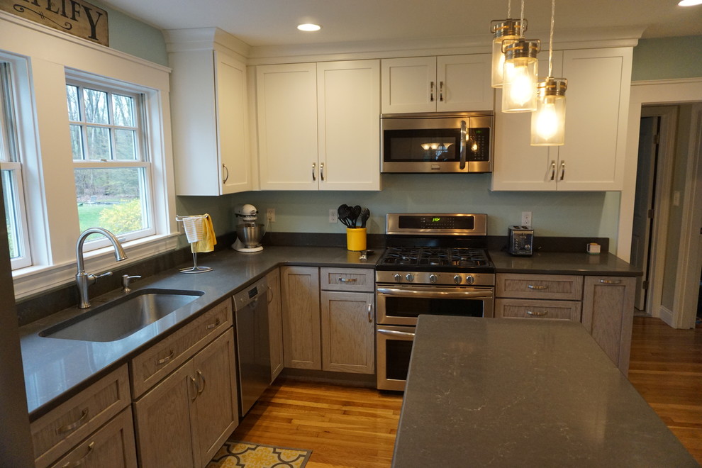 Inspiration for a mid-sized transitional u-shaped medium tone wood floor eat-in kitchen remodel in Boston with an undermount sink, shaker cabinets, gray cabinets, quartz countertops, black backsplash, stainless steel appliances and an island