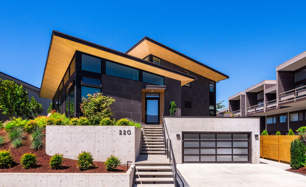 Mid-sized contemporary two-storey black house exterior in Seattle with stone veneer, a flat roof and a mixed roof.