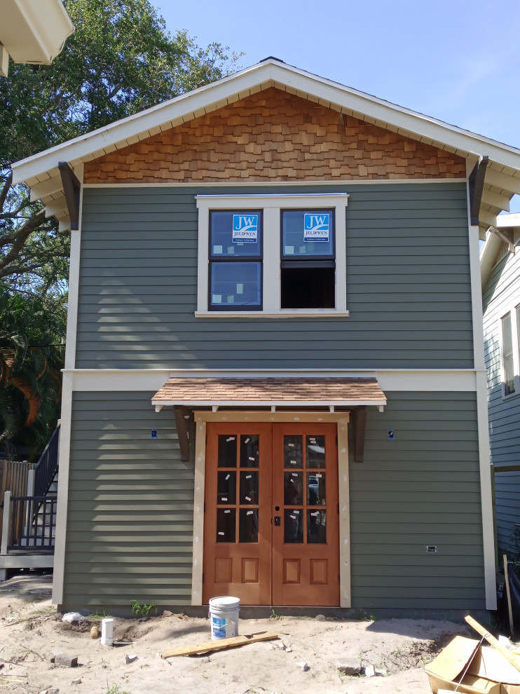 Kleines, Zweistöckiges Uriges Haus mit grauer Fassadenfarbe, Satteldach, Schindeldach, braunem Dach und Verschalung in Tampa