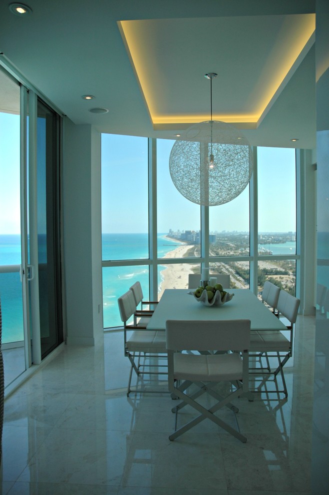 Photo of a large contemporary dining room in Miami with white walls, marble floors, no fireplace and white floor.
