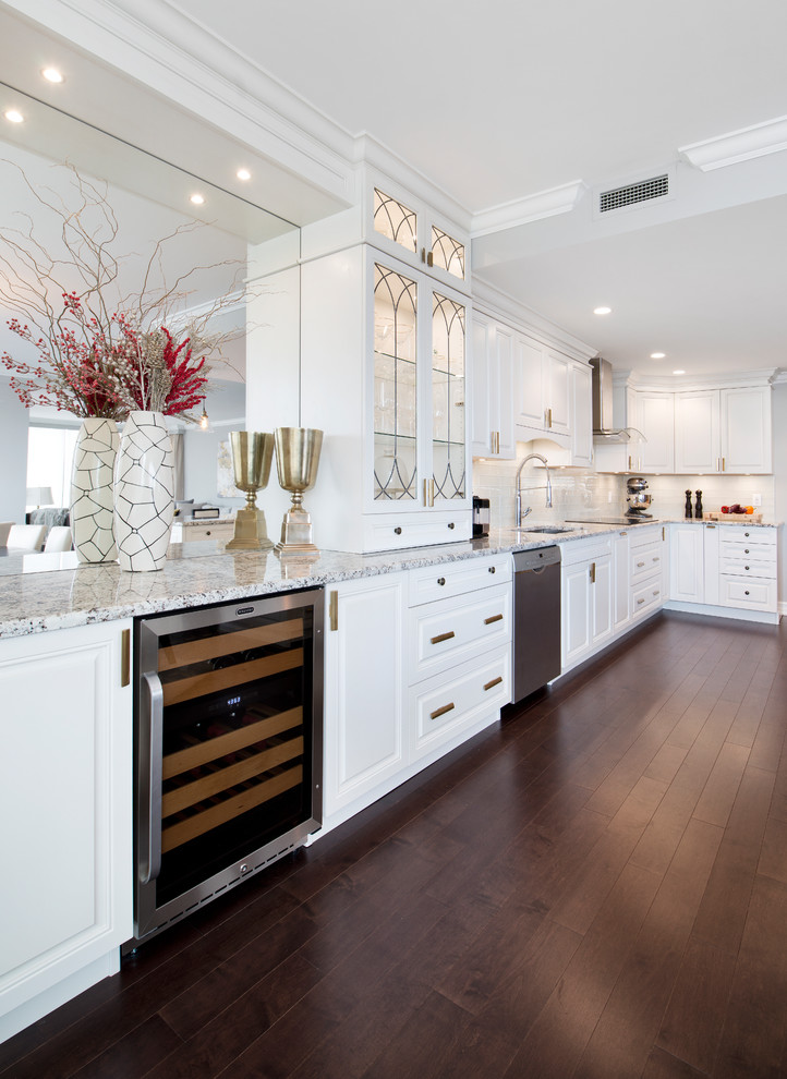 Design ideas for a large traditional l-shaped eat-in kitchen in Ottawa with an undermount sink, raised-panel cabinets, white cabinets, granite benchtops, white splashback, subway tile splashback, stainless steel appliances, dark hardwood floors, a peninsula and brown floor.