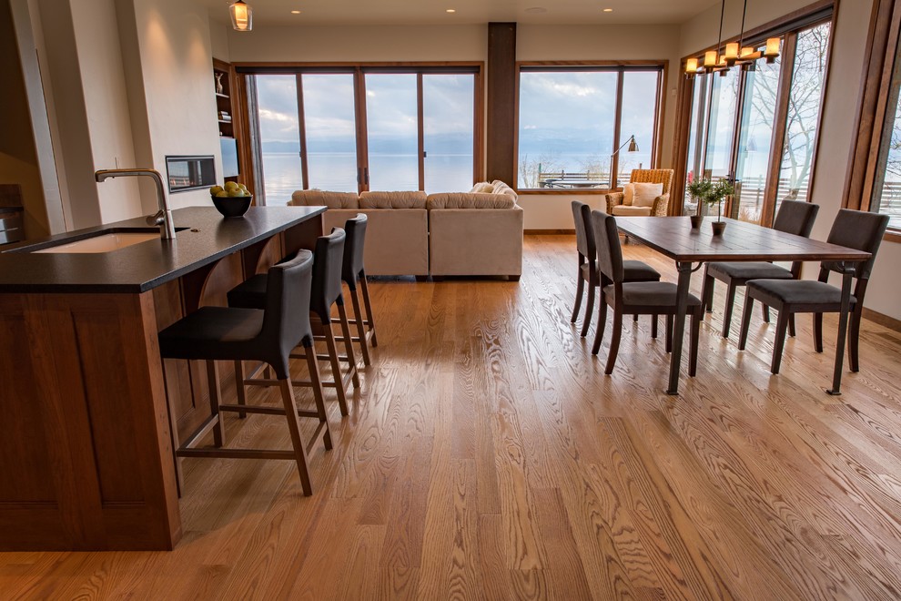 Inspiration for a large rustic l-shaped light wood floor and brown floor open concept kitchen remodel with an undermount sink, shaker cabinets, dark wood cabinets, quartzite countertops, brown backsplash, ceramic backsplash, stainless steel appliances and an island