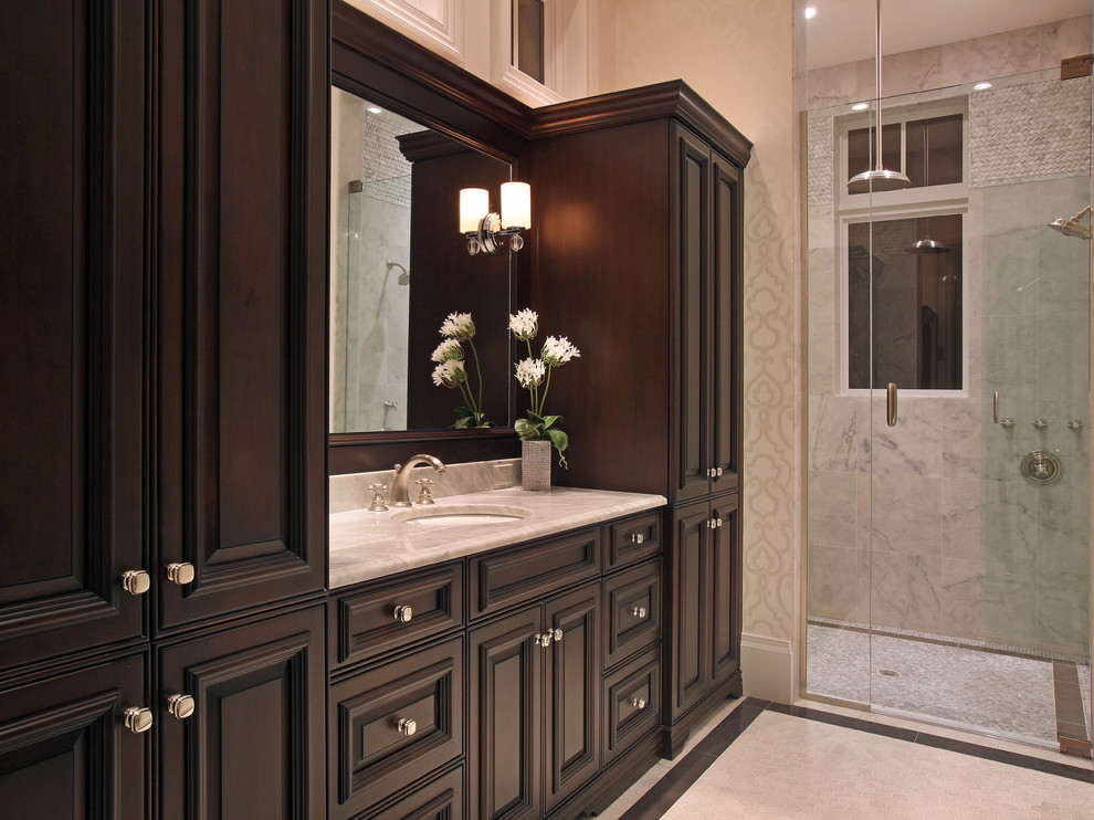 Design ideas for a traditional bathroom in Miami with raised-panel cabinets, dark wood cabinets and an alcove shower.