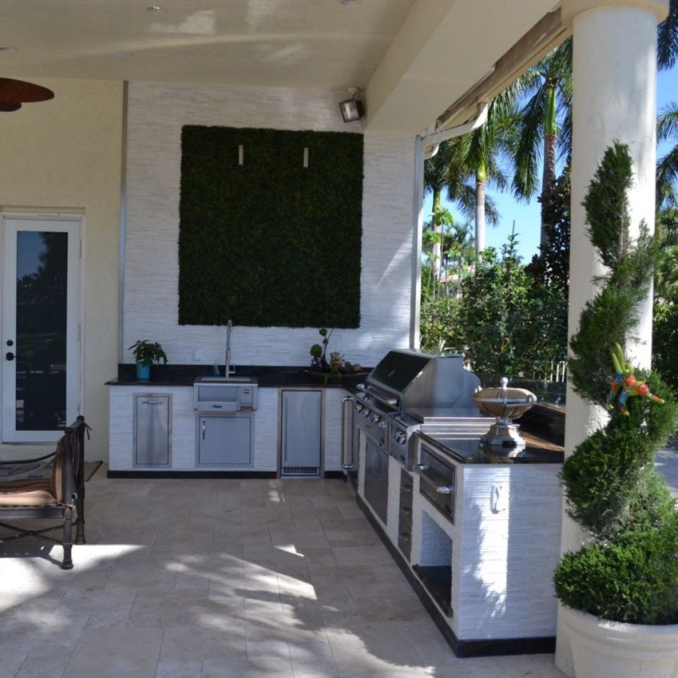 Photo of a large contemporary backyard patio in Tampa with an outdoor kitchen, stamped concrete and a roof extension.