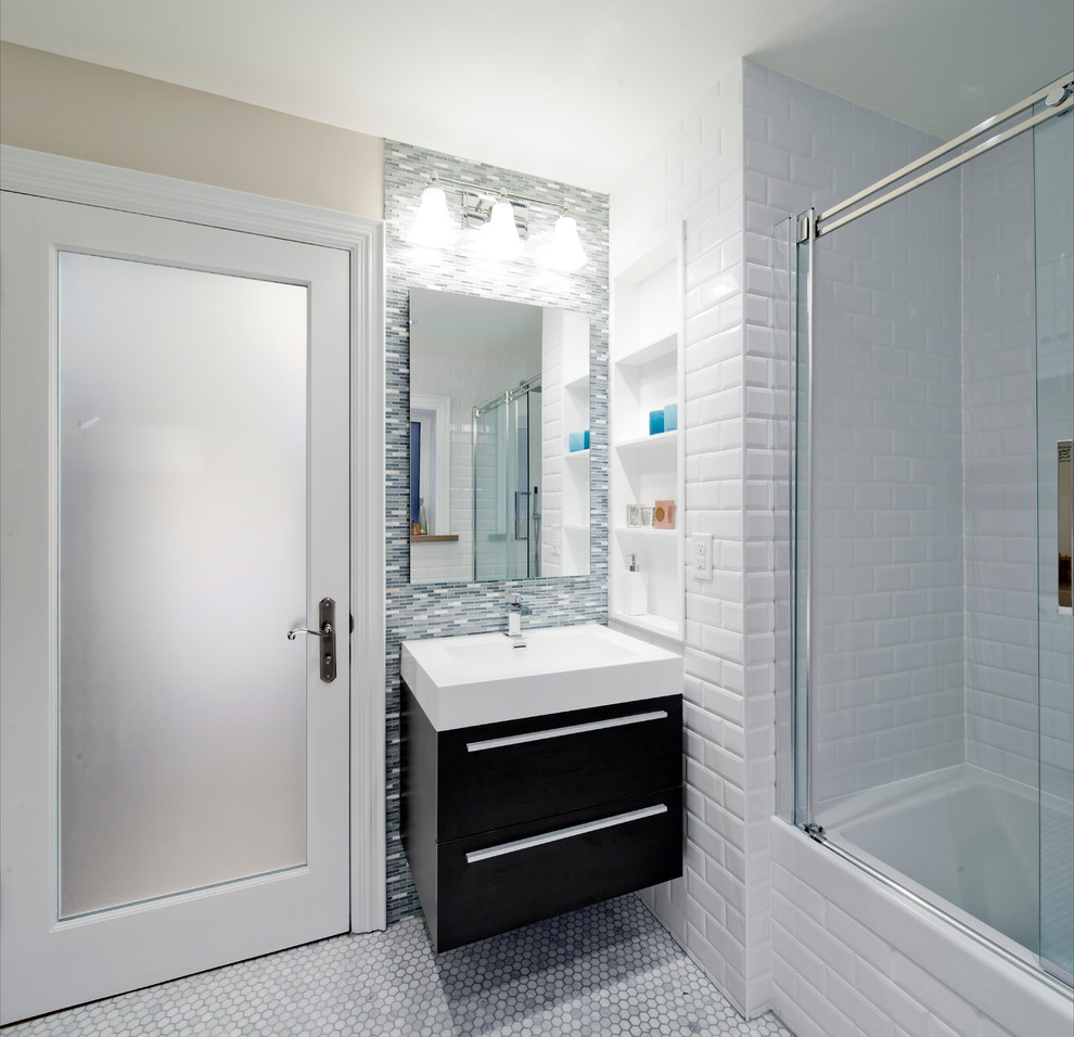 Small transitional master bathroom in Toronto with flat-panel cabinets, an alcove tub, a shower/bathtub combo, white tile, subway tile, dark wood cabinets, a one-piece toilet, beige walls, marble floors, a console sink and solid surface benchtops.