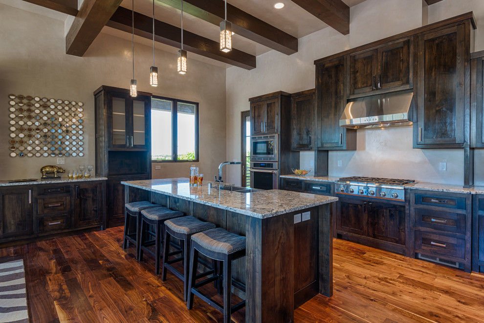 Large transitional single-wall dark wood floor eat-in kitchen photo in Albuquerque with a double-bowl sink, shaker cabinets, dark wood cabinets, granite countertops, beige backsplash, stainless steel appliances and an island