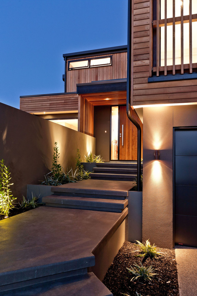 Large contemporary front door in Auckland with brown walls, concrete floors, a single front door and a dark wood front door.