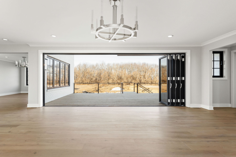 Inspiration for an expansive modern open concept family room in Indianapolis with white walls, light hardwood floors, a hanging fireplace and multi-coloured floor.
