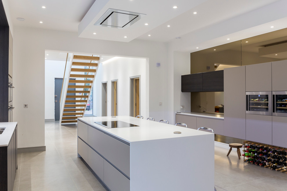 Photo of a contemporary kitchen in Essex with an undermount sink, flat-panel cabinets, white cabinets, stainless steel appliances and with island.