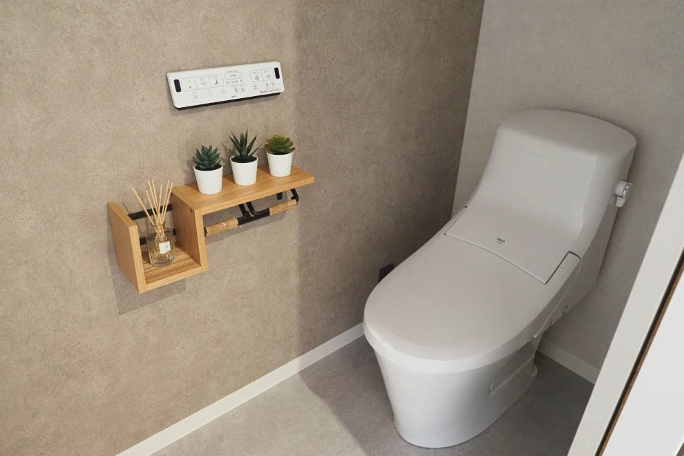 Inredning av ett modernt brun brunt toalett, med grå skåp, en toalettstol med hel cisternkåpa, grå kakel, grå väggar, vinylgolv och beiget golv