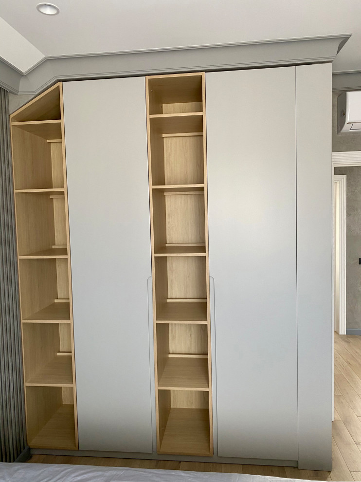 Design ideas for a mid-sized gender-neutral storage and wardrobe in Hertfordshire with flat-panel cabinets, grey cabinets, laminate floors, orange floor and exposed beam.
