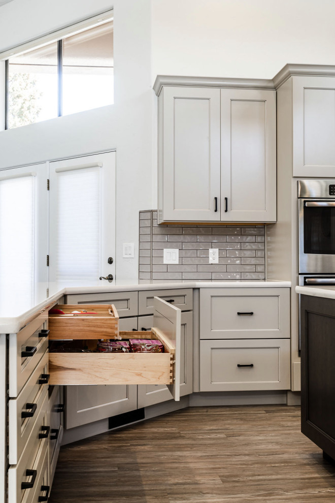 Large transitional u-shaped vinyl floor and gray floor eat-in kitchen photo with an undermount sink, shaker cabinets, gray cabinets, quartzite countertops, green backsplash, subway tile backsplash, stainless steel appliances, an island and white countertops