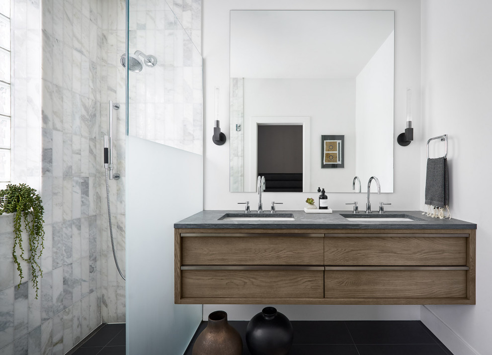 Inspiration for a mid-sized contemporary master bathroom in Chicago with flat-panel cabinets, medium wood cabinets, a curbless shower, white tile, marble, white walls, slate floors, an undermount sink, limestone benchtops, black floor, grey benchtops, an open shower, a double vanity and a floating vanity.