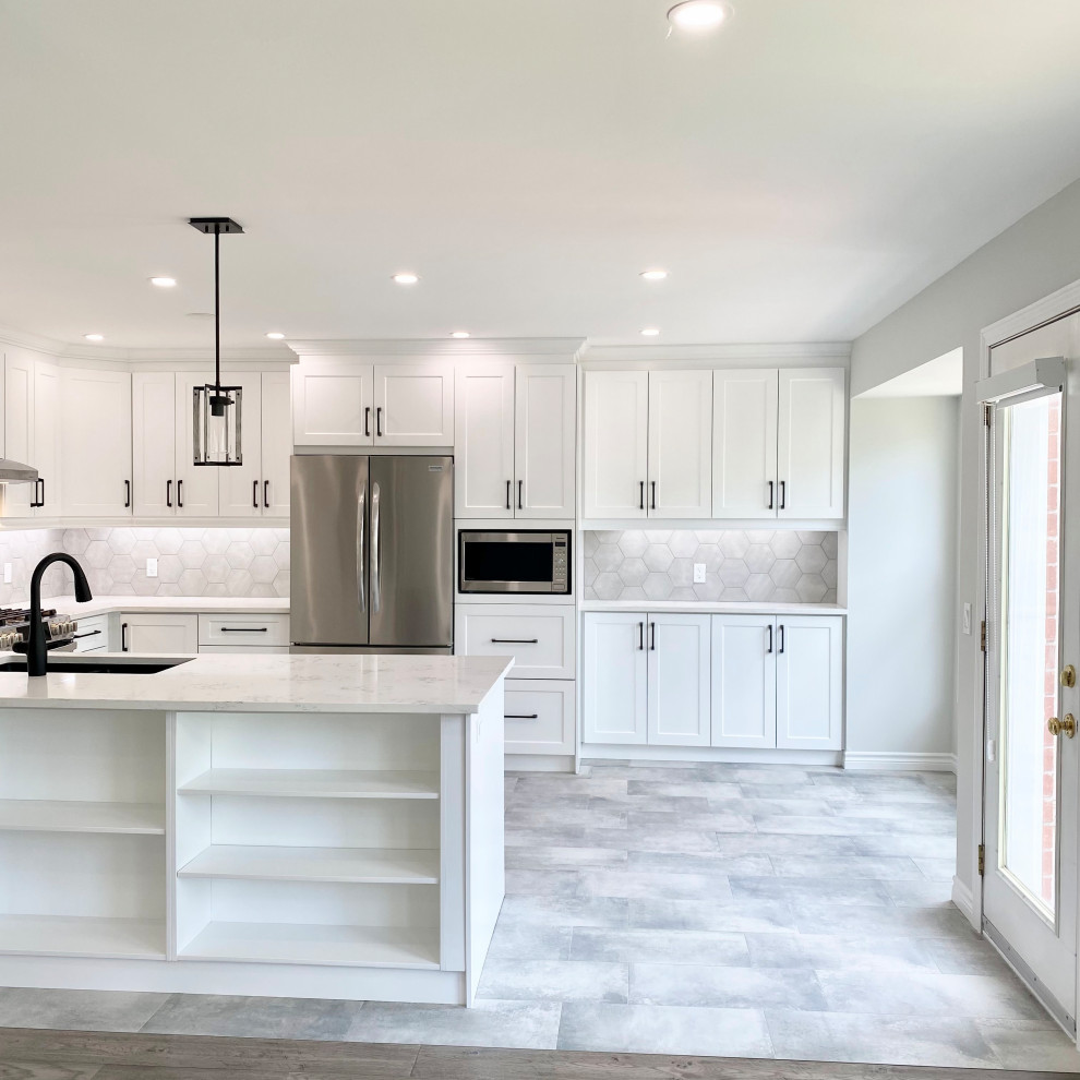 Inspiration for a large transitional u-shaped porcelain tile and gray floor open concept kitchen remodel with an undermount sink, recessed-panel cabinets, white cabinets, quartzite countertops, gray backsplash, stainless steel appliances, a peninsula and white countertops