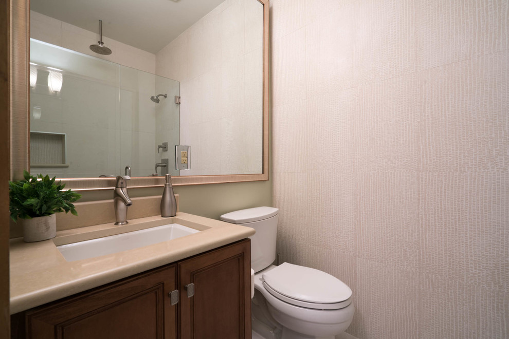 This is an example of a small transitional bathroom in Jacksonville with recessed-panel cabinets, medium wood cabinets, an open shower, a two-piece toilet, beige tile, porcelain tile, beige walls, porcelain floors, an undermount sink and engineered quartz benchtops.