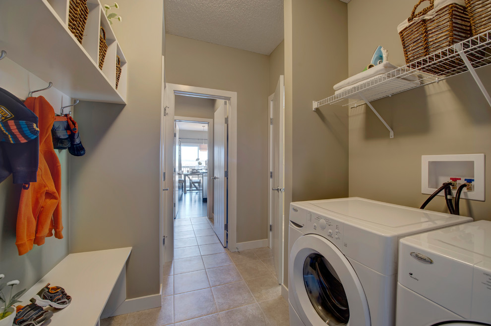 Design ideas for a mid-sized contemporary galley dedicated laundry room in Edmonton with beige walls, ceramic floors and a side-by-side washer and dryer.