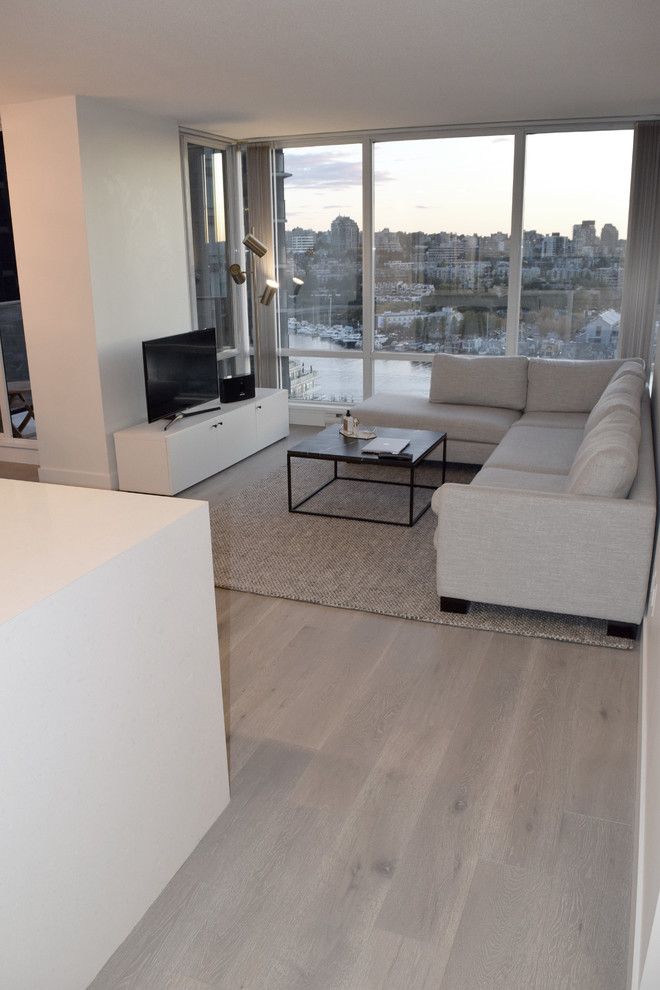 Example of a small minimalist formal and open concept light wood floor and brown floor living room design in Vancouver with white walls, no fireplace and no tv