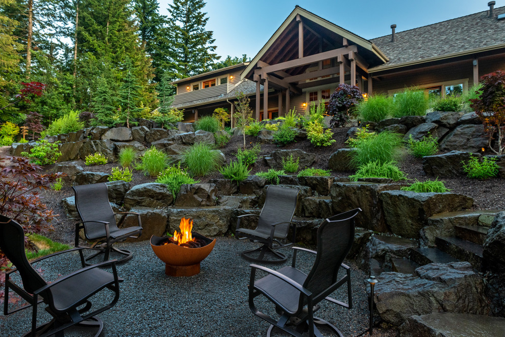 This is an example of a large arts and crafts backyard garden in Seattle with with rock feature and gravel.