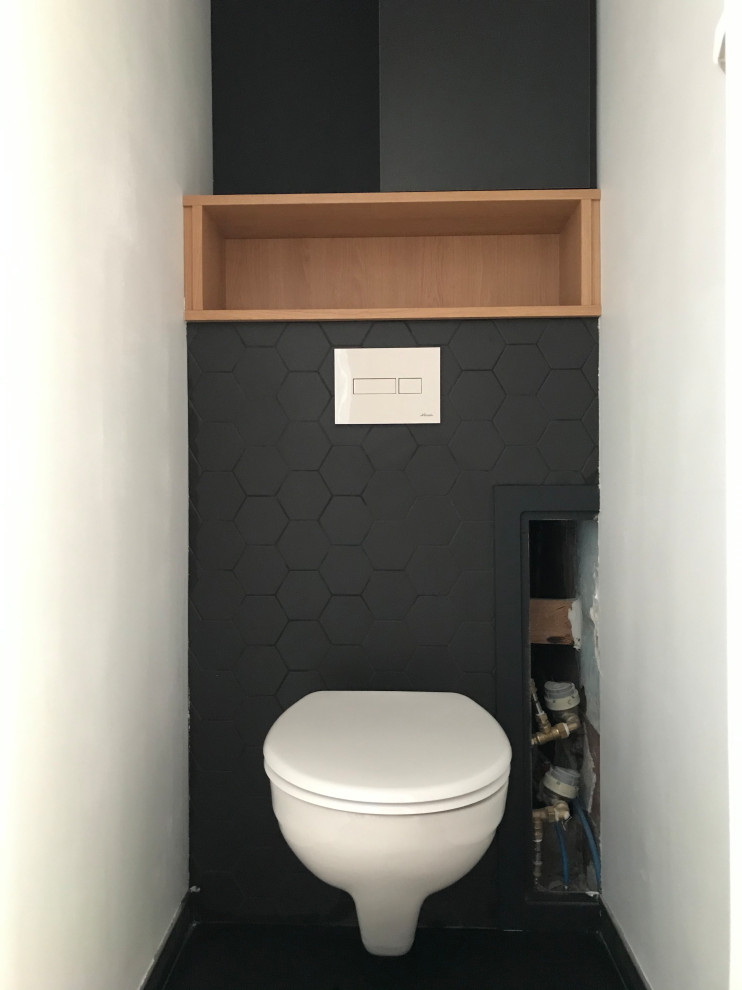 Стильный дизайн: маленький туалет в классическом стиле с черными фасадами, инсталляцией, черной плиткой, полом из керамической плитки, черным полом, плоскими фасадами, керамической плиткой, черными стенами и встроенной тумбой для на участке и в саду - последний тренд