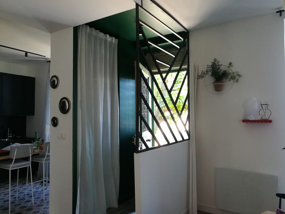 This is an example of a small eclectic vestibule in Lyon with green walls, ceramic floors, a single front door, a green front door and grey floor.