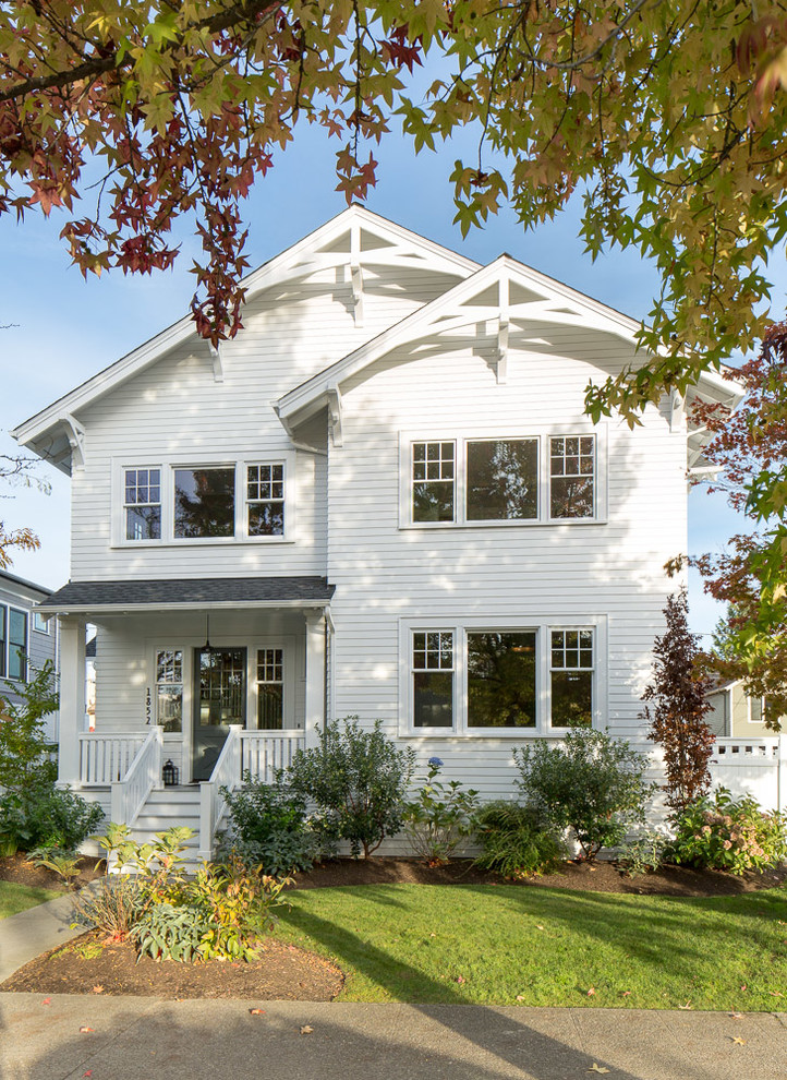 Photo of a large traditional three-storey white exterior in Seattle with wood siding.