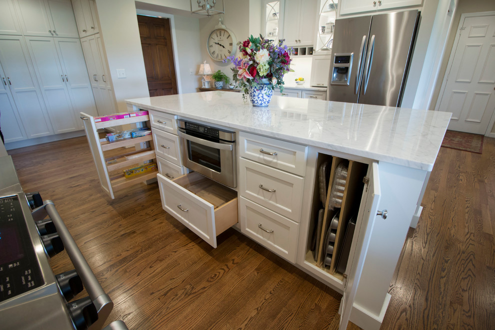 Inspiration for a huge transitional medium tone wood floor open concept kitchen remodel with an undermount sink, shaker cabinets, white cabinets, marble countertops, white backsplash, ceramic backsplash, stainless steel appliances and two islands