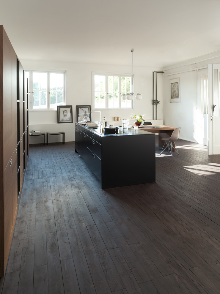 Design ideas for a mid-sized modern open plan kitchen in Stuttgart with flat-panel cabinets, black cabinets, panelled appliances, dark hardwood floors and with island.