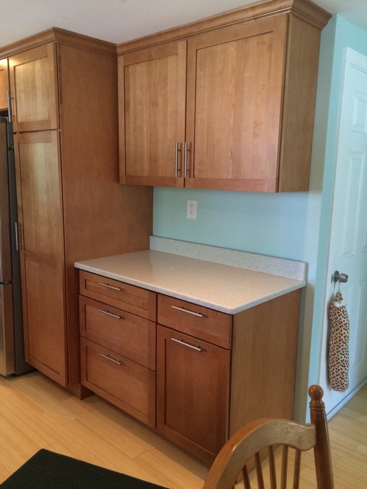 Inspiration for a transitional galley light wood floor eat-in kitchen remodel in Boston with an undermount sink, shaker cabinets, medium tone wood cabinets, quartz countertops, stainless steel appliances, no island and white countertops