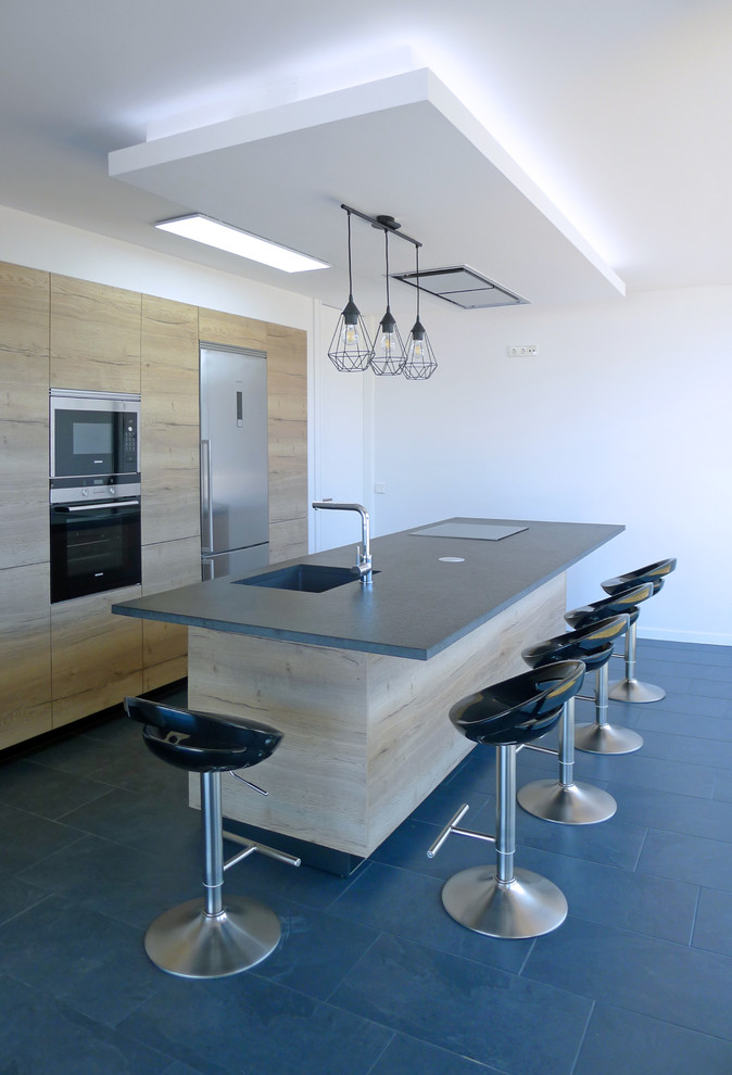Inspiration for a small contemporary kitchen in Other with light wood cabinets, granite benchtops, ceramic floors, with island, grey floor, a single-bowl sink, flat-panel cabinets, stainless steel appliances and grey benchtop.