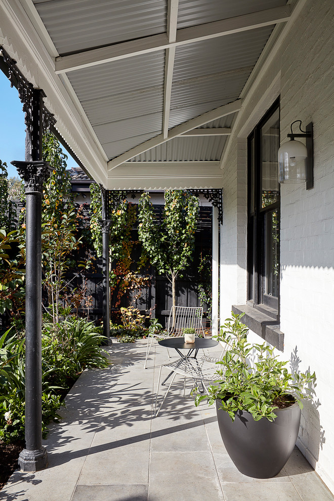 This is an example of a large contemporary one-storey concrete grey house exterior in Melbourne with a flat roof and a metal roof.