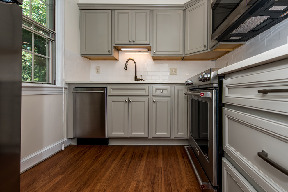 Inspiration for a small transitional l-shaped vinyl floor and brown floor eat-in kitchen remodel in DC Metro with an undermount sink, shaker cabinets, gray cabinets, quartz countertops, white backsplash, porcelain backsplash, stainless steel appliances and no island