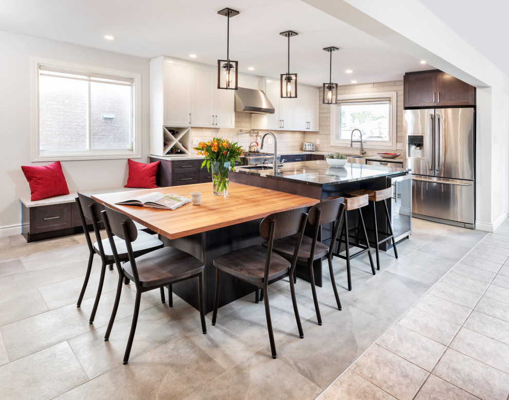 Inspiration for a transitional u-shaped concrete floor and gray floor eat-in kitchen remodel in Ottawa with a farmhouse sink, shaker cabinets, dark wood cabinets, beige backsplash, subway tile backsplash, stainless steel appliances and an island