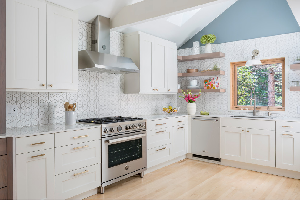 Photo of a mid-sized scandinavian u-shaped kitchen in Minneapolis with a double-bowl sink, flat-panel cabinets, white cabinets, white splashback, ceramic splashback, stainless steel appliances, light hardwood floors, no island, yellow floor and white benchtop.