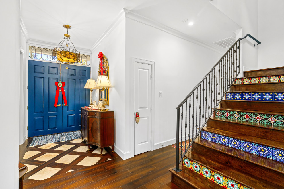 Idée de décoration pour une grande porte d'entrée tradition avec un mur blanc, un sol en bois brun, une porte double, une porte bleue et un sol marron.